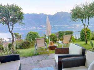 a patio with two chairs and an umbrella at Sonnenstrahl in Locarno