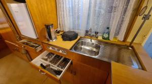 a small kitchen with a sink and a counter top at Quiet caravan in nature on Mur cycle path in Feldkirchen bei Graz