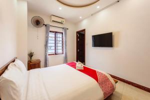 a bedroom with a large bed and a flat screen tv at Hoi An Legend Connect Villa in Hoi An