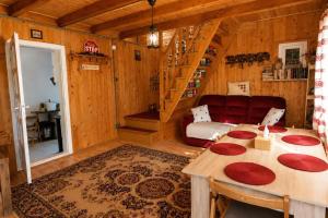 a living room with a red couch and a table at Casa Bando in Moacşa +20 photos