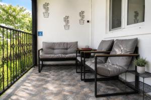 a patio with two chairs and a table on a balcony at Casa Bando in Moacşa