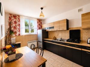 a kitchen with a table and a refrigerator and a sink at Cichy Potok in Polańczyk