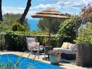 a patio with a couch and an umbrella next to a pool at le lodge Saint Clair in Sète