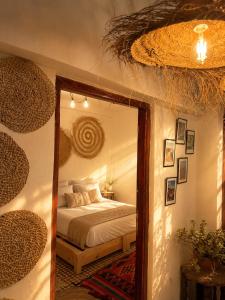 a bedroom with a bed and a large mirror at Riad Boya Surf - Lodge in Agadir