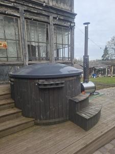 a building with a hot tub on a deck at Pavasari in Cēsis