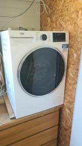 a white washing machine sitting on top of a counter at Quiet caravan in nature on Mur cycle path in Feldkirchen bei Graz +7 photos