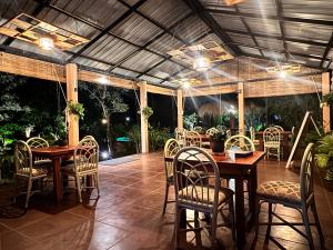 a dining room with tables and chairs in a patio at The Cottage Sigiriya in Sigiriya