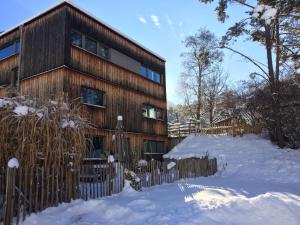 una casa en la nieve con una valla en Apartment Amberg en Ötztal-Bahnhof