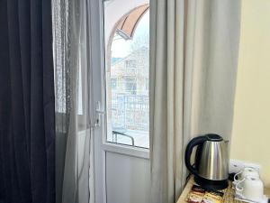 a door to a window with a tea kettle on a table at Hotel Basen in Sisian