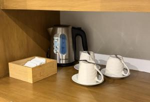 a coffee maker and two cups and a wooden box at Casitas de Boracay in Boracay