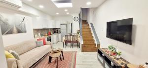 a living room with a couch and a tv and a kitchen at THOMAS LUXURY MAISONETTE in the Historical Center of Ioannina in Ioannina