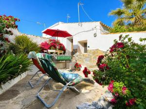 a chair in a garden with a table and an umbrella at Cortijo Paraiso Pool & Tropical Garden Oasis in Cúllar de Baza