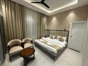 a bedroom with a bed and a table and chairs at Hotel Bloom Residency in Dehradun