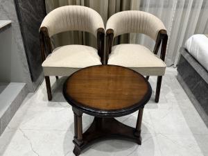 two chairs and a table in a room at Hotel Bloom Residency in Dehradun