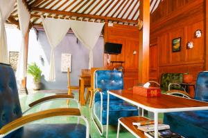 a dining room with blue chairs and a table at Villa Joglo Kawung - City Centre Paradise with Pool in Yogyakarta