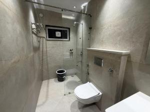 a bathroom with a white toilet and a shower at Hotel Bloom Residency in Dehradun