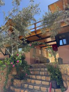 a house with some flowers on the stairs at Dana in Tufailah