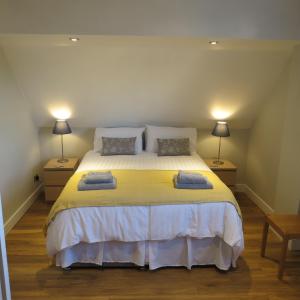 a bedroom with a large bed with two lamps at Maltings Loft in Hepworth
