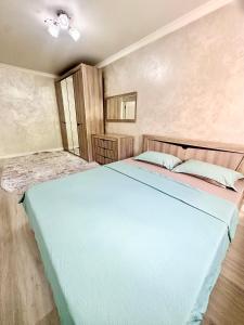 a bedroom with a large blue bed in a room at Apartment Plaza tower in Shymkent