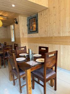 a dining room with a wooden table and chairs at Hotel Devachan & Restaurant in Tāndi
