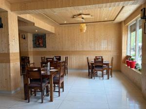 a dining room with wooden tables and chairs at Hotel Devachan & Restaurant in Tāndi