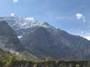 a snow covered mountain in front of a blue sky at Hotel Devachan & Restaurant in Tāndi