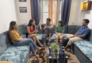 a group of people sitting on a couch at The Basecamp Dorm in Siliguri
