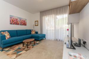 a living room with a blue couch and a table at Al Col de Foia in Agordo