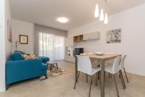 a living room with a blue couch and a table at Al Col de Foia in Agordo