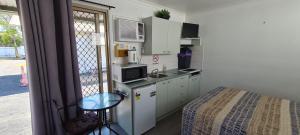 a small kitchen with a sink and a bed in a room at Rivergums Caravan Park in Goondiwindi