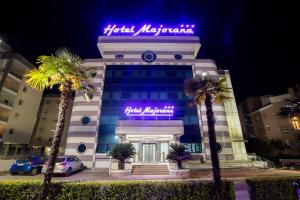 a building with a neon sign on top of it at Hotel Majorana in Rende