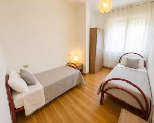 a bedroom with two beds and a window at Residence Caorle Apartments - Agenzia Cocal in Caorle