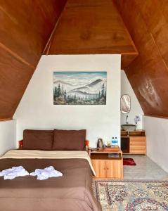 a bedroom with a bed and a table in a room at Roman Villa Syariah in Sembalun Lawang