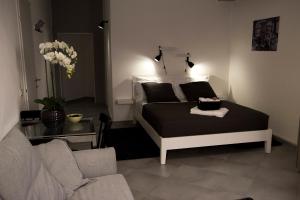 a bedroom with a bed and a living room with a couch at B&B Gallidoro in Palermo