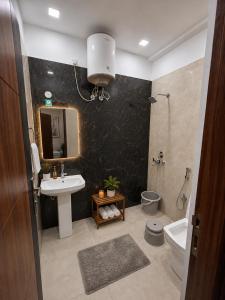 a bathroom with a sink and a mirror and a toilet at Casa Nova Stays in Dehradun