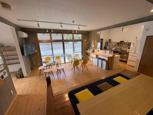 a living room and kitchen with a table and chairs at Hostel Mosura no Tamago in Motobu