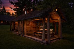 a wooden cabin with a table in the grass at Sepasauna holiday house in Joaveski