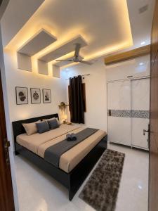 a bedroom with a large bed with a ceiling at Casa Nova Stays in Dehradun