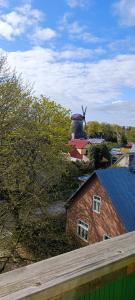 a view of a house with a windmill in the background at Uueka Külaliskorter in Kuressaare
