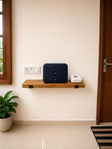 a laptop sitting on a wooden shelf on a wall at Casa Nova Stays in Dehradun