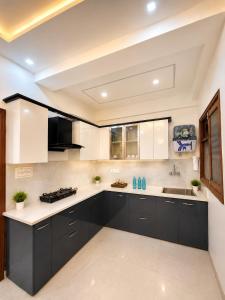 a kitchen with black cabinets and a sink at Casa Nova Stays in Dehradun