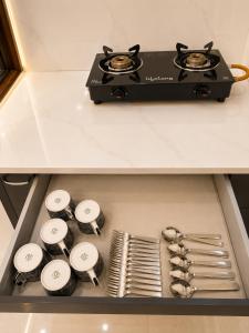 a drawer with a stove and utensils in it at Casa Nova Stays in Dehradun +16 photos
