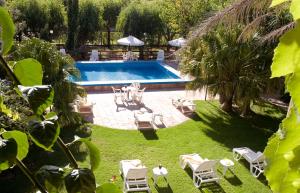 a backyard with a swimming pool with chairs and a table at Hotel Riviera in Villa Gesell
