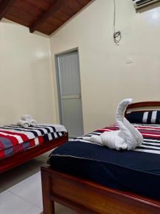a bedroom with two beds and a white towel at Hostal Yurag Wasi in Nuevo Rocafuerte