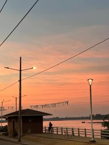 a person sitting on a bench in front of the water at Hostal Yurag Wasi in Nuevo Rocafuerte