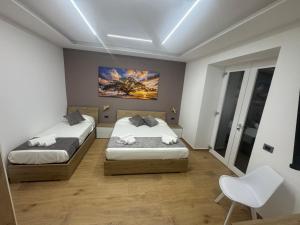 a bedroom with two beds and a painting on the wall at Costa blu in Agropoli