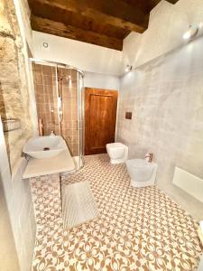 a bathroom with two toilets and a sink and a shower at Nonna Pia in Noto