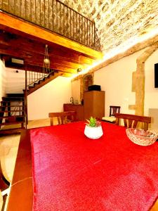 a room with a red table with a red rug at Nonna Pia in Noto