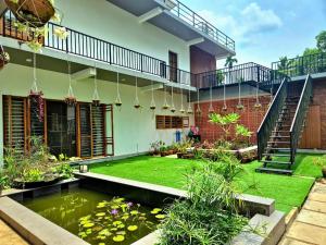 a garden with a koi pond in front of a house at Prabhu Villla Upper Deck in Perumpāvūr