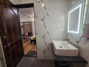a bathroom with a sink and a mirror at New Vyankatesh in Mahabaleshwar